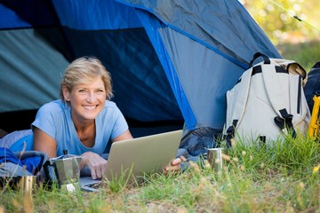 Poster - Mature woman smiling and using computer 