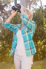 Poster - Mature woman looking on binoculars 