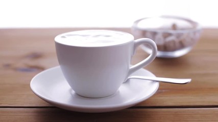 Poster - cream pouring to coffee cup on wooden table