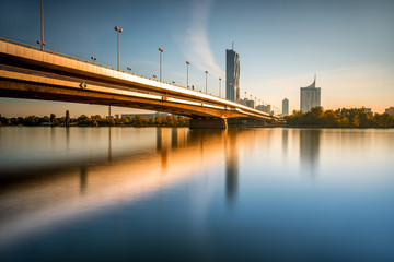 Wall Mural - View on Donaucity with bridge in Vienna in the morning. Wide angle image with long exposure technic with glossy water and reflection