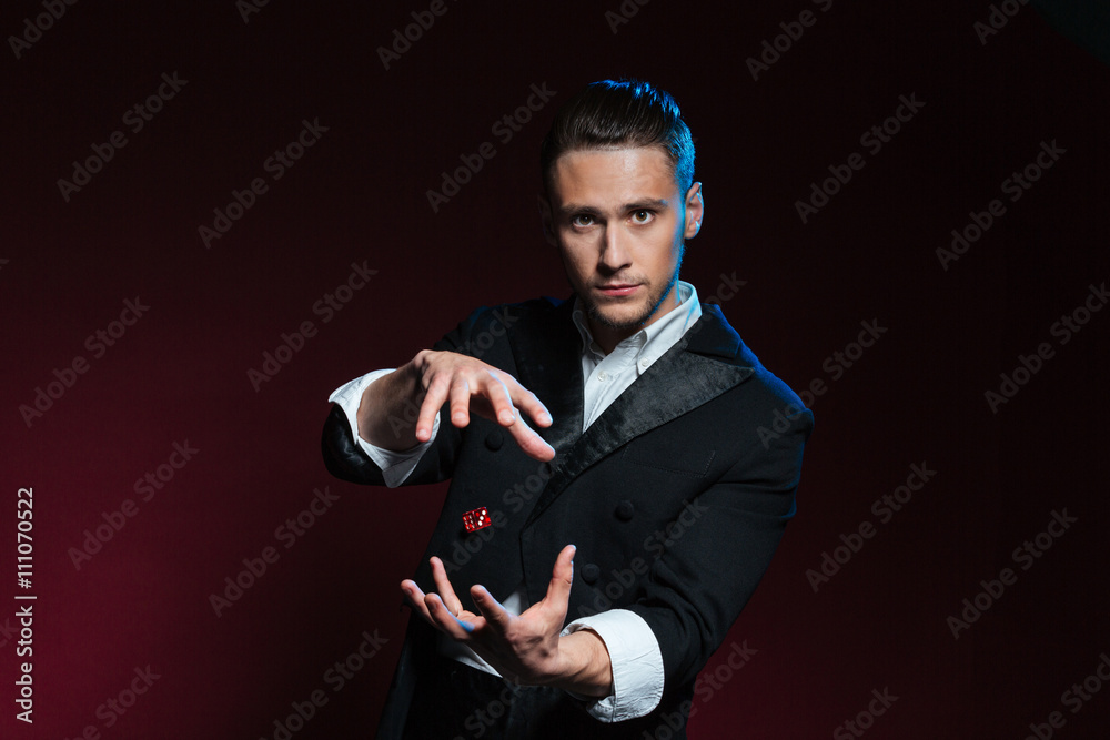 Confident young man magician showing tricks using one flying dice Stock ...