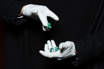 Hands of man magician in white gloves holding casino chips