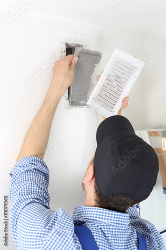 Fotografie, Obraz Handwerker öffnet Deckel mit Filter eines Luftschachtes zum Filterwechsel