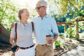 Wall Mural - Loving mature couple walking together in a park