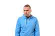 Grumpy man in blue sweater near white wall