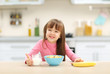 © Africa Studio - Beautiful little girl having breakfast with cereal, milk and banana in kitchen