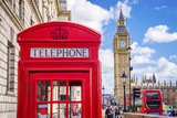 Fototapeta Londyn - Traditional red british telephone box with Big Ben and Double Decker bus at the background on a sunny afternoon with blue sky and clouds - London, UK