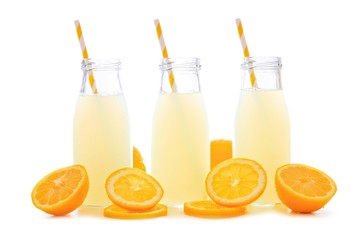 Three bottles of cold lemonade with lemon slices and straws isolated on a white background