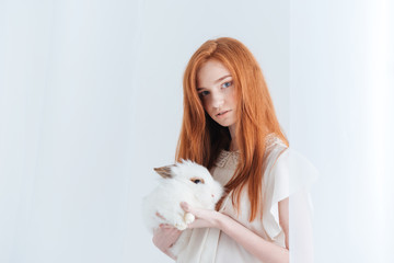 Sticker - Attractive redhead woman holding rabbit