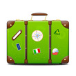 Green suitcase with stickers on surface