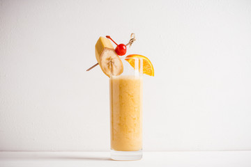 Banana cocktail with fruit decoration on the wooden background