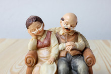 Lovely Grandparent Dolls Sleeping With A Book On Wood Background
