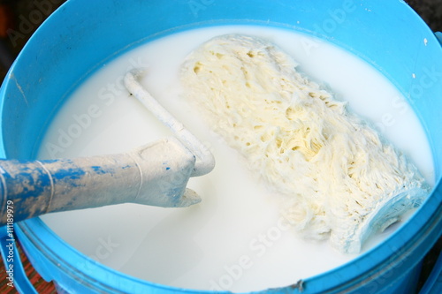 Fotografía rinçage de rouleau de peinture à l'eau dans sceau