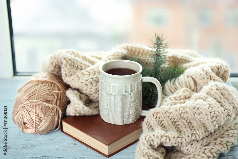 Beautiful winter composition on windowsill with cup of hot drink