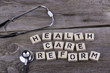 Text: HEALTH CARE REFORM from wooden letters on wooden backgroun