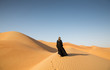 © katiekk2 - A woman in abaya in sanddunes in Liwa Desert, Aby Dhabi, UAE