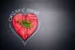 © VICUSCHKA - Organic meat for healthy Eating. Heart shape raw meat with herbs and text on black blank chalkboard background, top view
