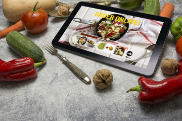 Tablet with Online food delivery app on screen. lifestyle concep