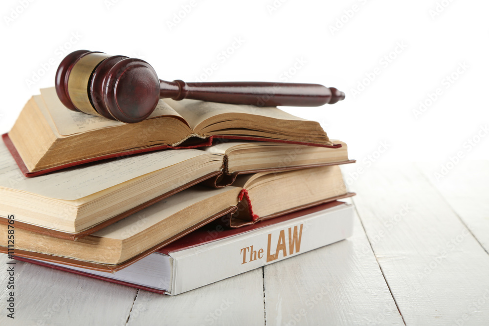 Gavel and books on wooden table on white background