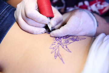 Wall Mural - Master doing tattoo on female  body, closeup