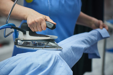 Wall Mural - Hands smoothing the shirt with the iron