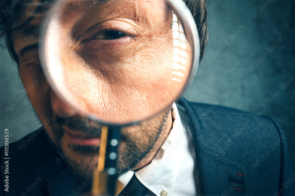 Enlarged eye of tax inspector looking through magnifying glass - obrazy, fototapety, plakaty 