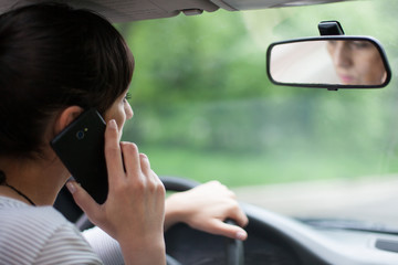 woman driving and using cell phone