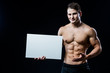 © romankosolapov - Full body bodybuilder with blank white poster isolated on black background. Handsome muscular man holding gray board copyspace in hands.