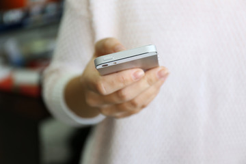 Canvas Print - Woman holding smartphone indoors