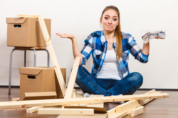 Wall Mural - Woman moving in holding screws and furniture parts