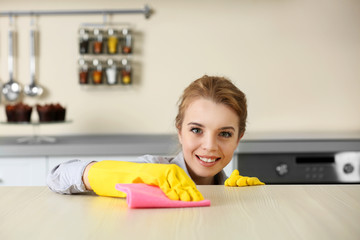 Wall Mural - Young woman scrubbing the bar in kitchen