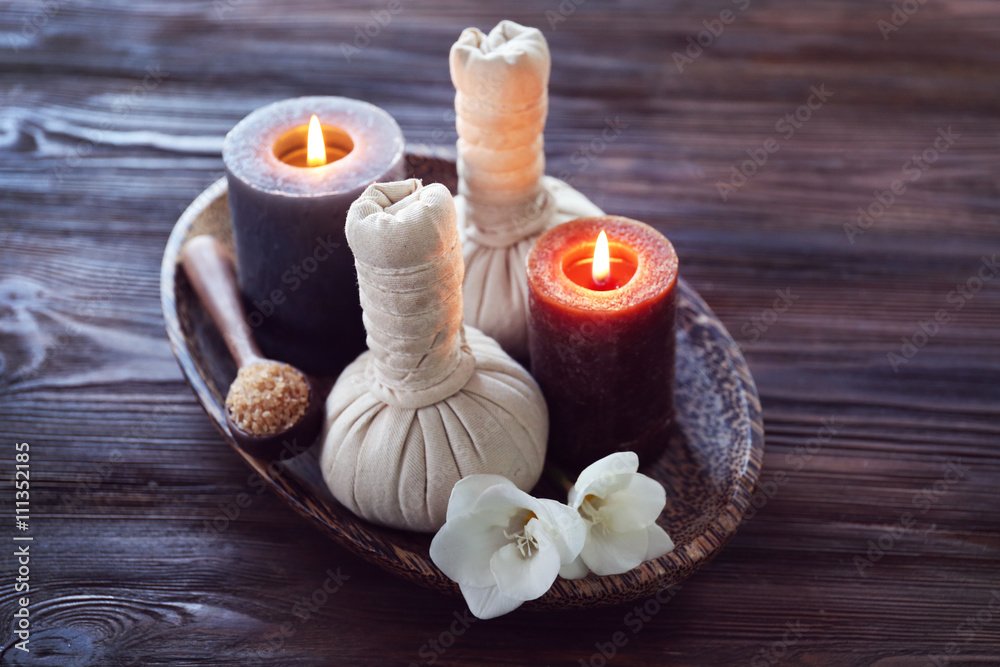 Spa composition with alight candles and beautiful flowers on wooden background
