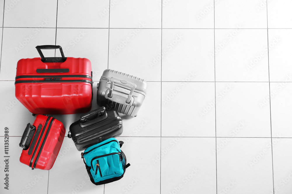 Different suitcases on tile floor, top view