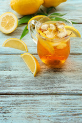 Wall Mural - Glass of ice lemon tea on wooden table