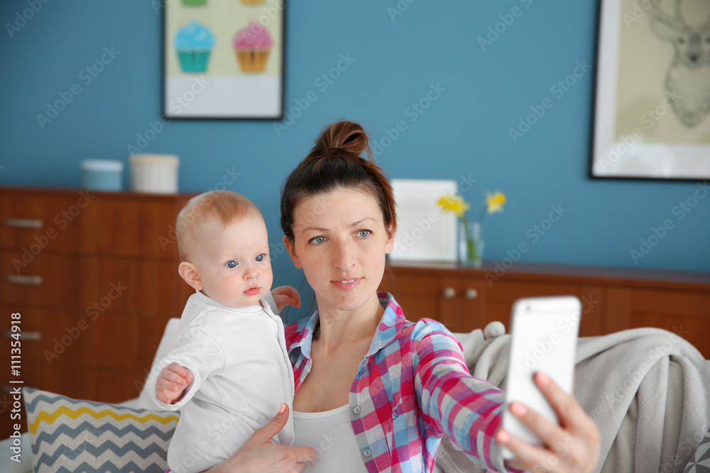 Young mother taking a selfie with her baby