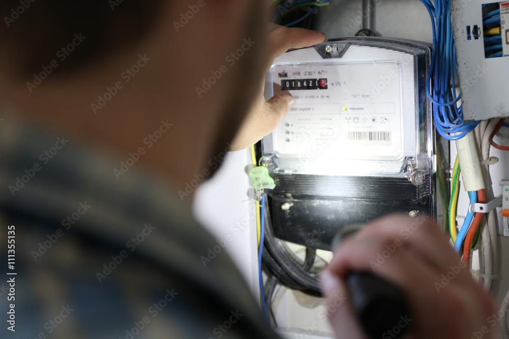 Man with flashlight checking switch box closeup