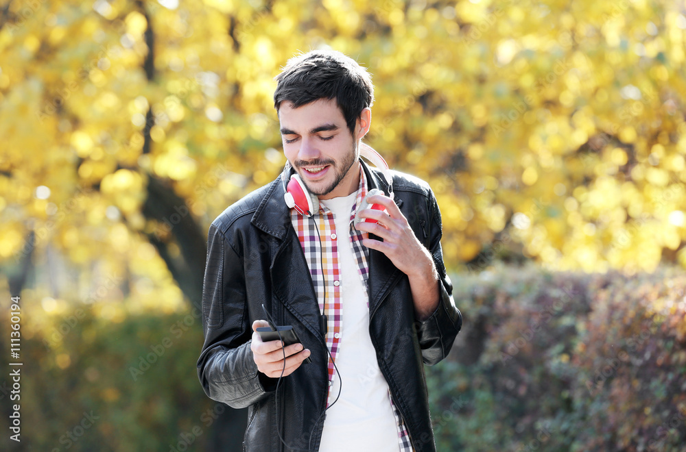 Young man in a park listening to music