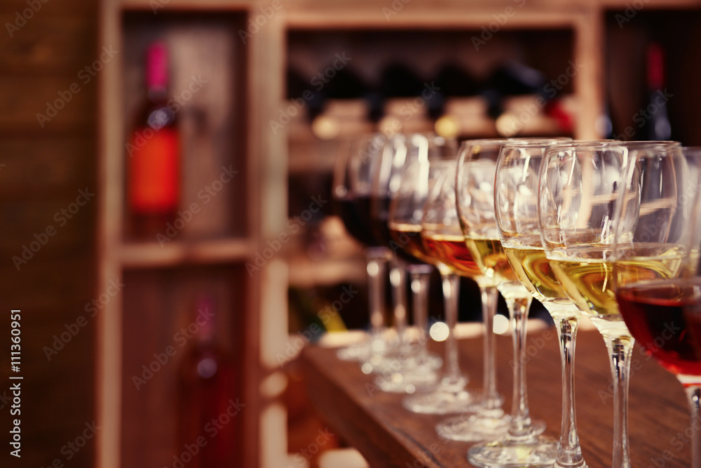 Many glasses of different wine in a row on bar counter