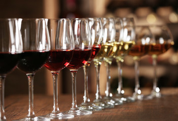 Wall Mural - Many glasses of different wine in a row on bar counter