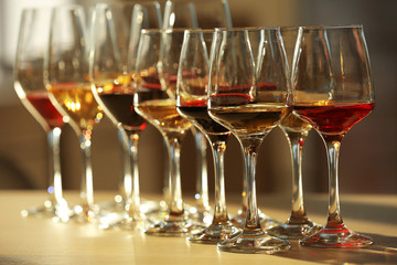 Canvas Print - Many glasses of different wine in a row on a table