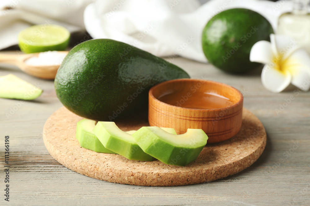 Still life with avocado oil on wooden background