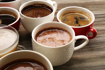 Sticker - Different cups of coffee on wooden table closeup