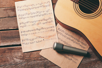 Wall Mural - Guitar and microphone on wooden background