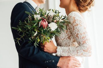bride and groom together holding wedding bouquet