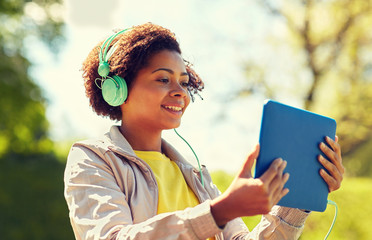 Wall Mural - happy african woman with tablet pc and headphones