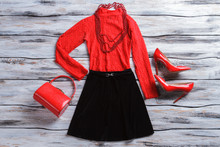 Red Top With Black Skirt. Glossy Heel Shoes And Necklace. New Design And Quality Fabric. Girl's Clothing On Wooden Showcase. 