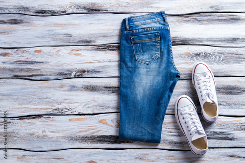 Blue Jeans And White Keds Folded Denim Pants And Shoes
