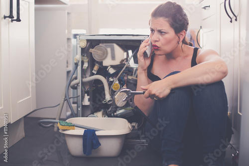 Fotografía Woman is calling a plumber to repair the leak