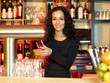 Woman bartender with a glass of beer at work