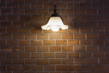 Wall Mural - Wall desk lamp shining on brick stone wall.